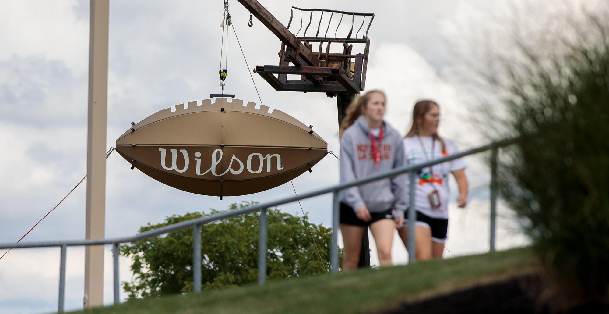 Students walk past the giant Wilson football outside of Dial-Roberson Stadium on the campus of 葫芦影业.
