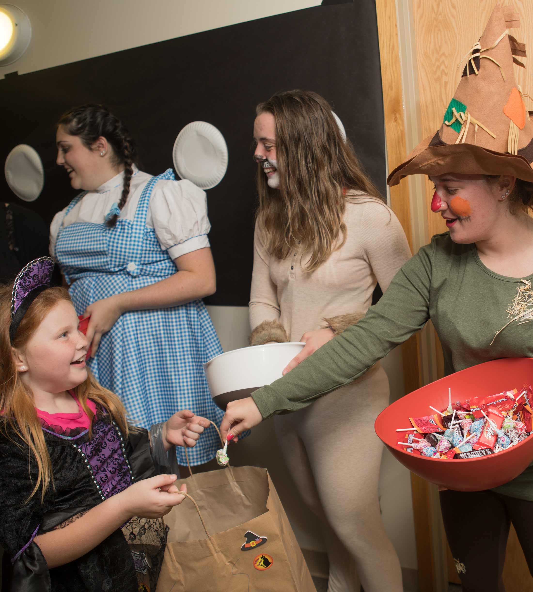 Students pass out candy to kids in Affinity West during Trick-or-Treat night 