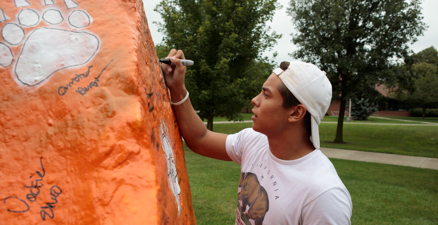 New student signing the spirit rock during welcome weekend.